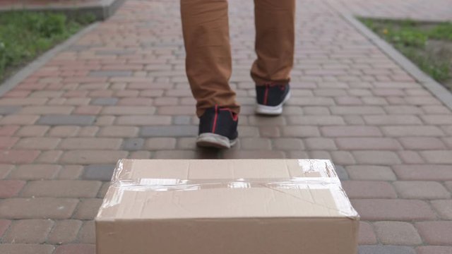 The courier delivers the package on the doorstep of the house. Food delivery during a pandemic, coronavirus.	