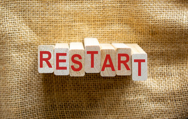 Wooden blocks form the word 'restart' on beautiful canvas background.