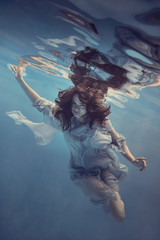 Portrait of a girl in a blue dress under water