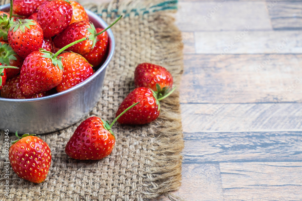 Wall mural .healthy fresh strawberry fruit in a bowl on a wooden table