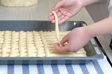 Women's hands prepare a sweet cake at home. Making a sweet cake. Girl forms a pie from yeast dough...