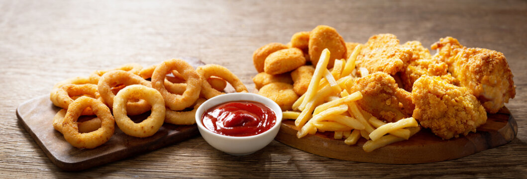 fast food meals : onion rings, french fries, chicken nuggets and fried chicken