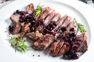 Closeup of Juicy steak sliced with rosemary and berry jam