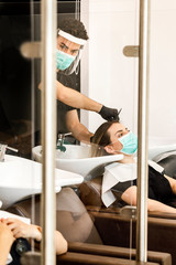 Servizio di lavaggio capelli dentro un salone da parrucchieri con tutte le disposizioni di...