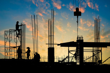 construction site at sunset with silhouette workers