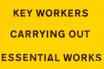 London, U.K. - 14 May 2020: A roadsign alerts people to key workers carrying out essential works