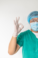 happy male doctor with medical mask in hospital showing ok hand sign, safety sign.