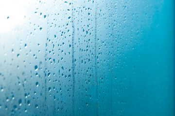 Drops of water flowing from a glass window. Condensate, heat, cold, humidity concept.