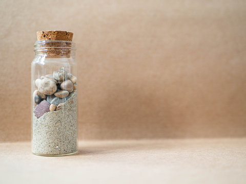 Jar with sand and beach stones
