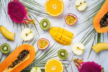 Exotic fruits and tropical leaves on table
