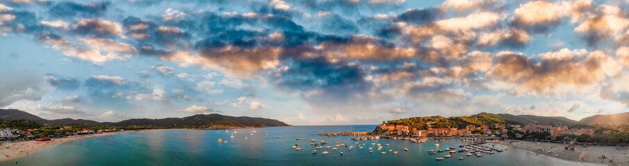 Fototapeta premium Aerila view of Marina di Campo coastline at sunset, Elba Island - Italy
