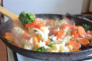 Mixed fresh vegetables in a skillet, жаренные тушенные овощи на сковороде, с деревянной ложкой, овощное рагу из броколли, цветной капусты и моркови, вегетарианец, диета, мало калорий