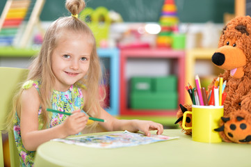 Fototapeta premium Cute beautiful little girl drawing at table