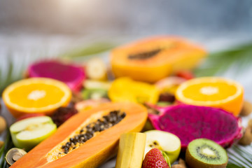 Exotic fruits and tropical leaves on table