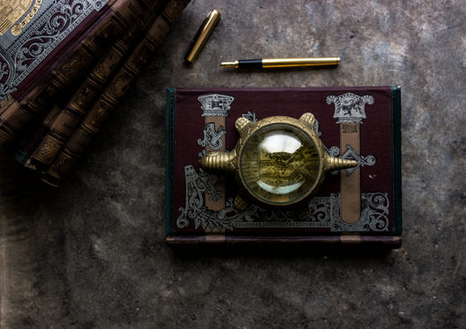old magnifying glass and vintage books.