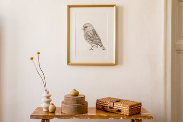 Stylish concept at living room interior with gold mock up frame, wooden bench, boxes, dried flowers...