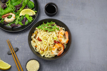 Stir fry noodles with vegetables and shrimps in bowl. Top view. Copy space.