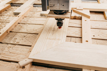 Close-up of cutting wood on a CNC milling machine in garage