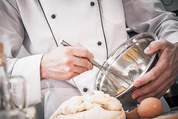 Chef Whisking Batter And Preparing Dough In Kitchen.