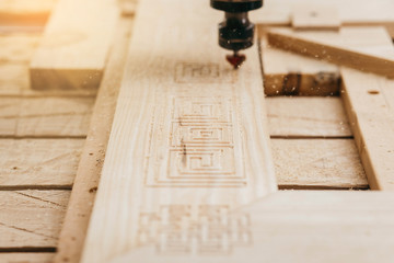 Close-up of cutting wood on a CNC milling machine in garage
