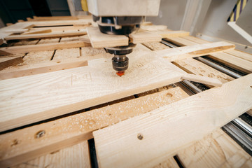 Close-up of cutting wood on a CNC milling machine in garage