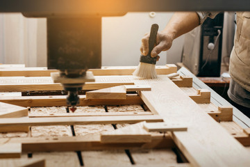 Man cleaning wood  CNC milling machine