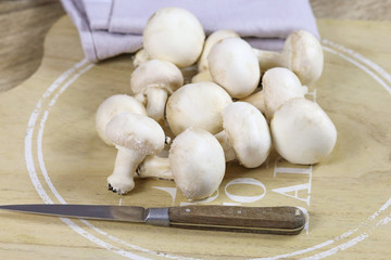 champignons de paris cru sur une planche à découper