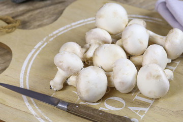 champignons de paris cru sur une planche à découper