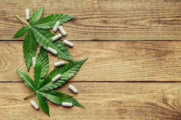 Cannabis Sativa Leaves On Dark.Assorted cannabis products, pills and cbd oil - medical marijuana concept,alternative herb medicine.
