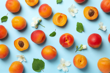 Fresh tasty apricots on blue background, top view