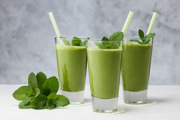 Freshly blended green fruit smoothie in glass.