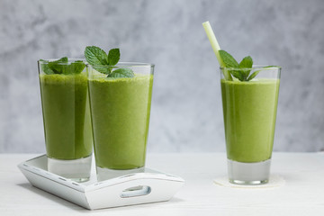 Freshly blended green fruit smoothie in glass.