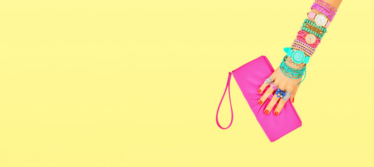 Fashion. Trendy handbag clutch, female hand, accessories set. Minimal design. Stylish wrist watches, jewelry, summer fashionable woman. Creative art shopping concept on yellow, summertime