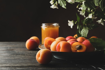 Composition with apricots and jam on wooden background