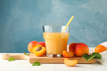 Composition with tasty apricots and juice on wooden table