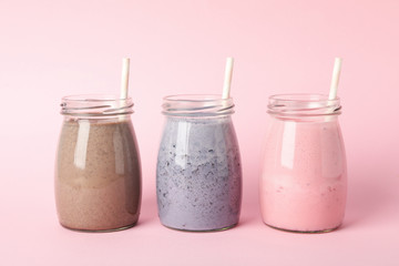 Blueberry, strawberry and chocolate milkshakes on pink background. Delicious drink