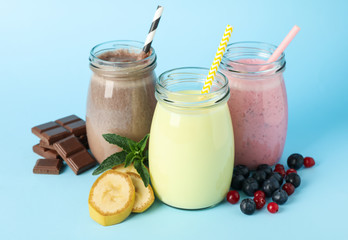 Delicious milkshakes on blue background. Summer drink