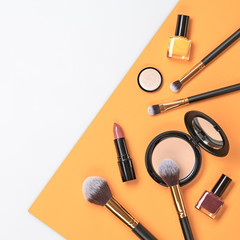 Beauty cosmetic makeup set. Fashion woman make up product, brushes, lipstick, nail polish collection. Creative orange concept. Cosmetology make-up accessories, top view.