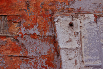 Part of a brick wall with peeling white, gray and red paint. There is a place for text. Street photo made specifically for your original design.