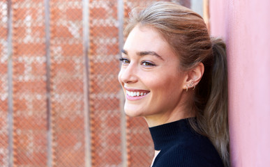 Outdoor Head And Shoulders Portrait Of Attractive Young Woman Standing In The Street