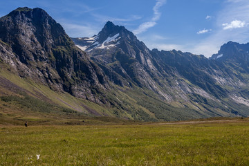 ROMEDALEN, NORWAY - 2014 JULY 21. One person in the background hiking in the Norwegian valley with big mountains.