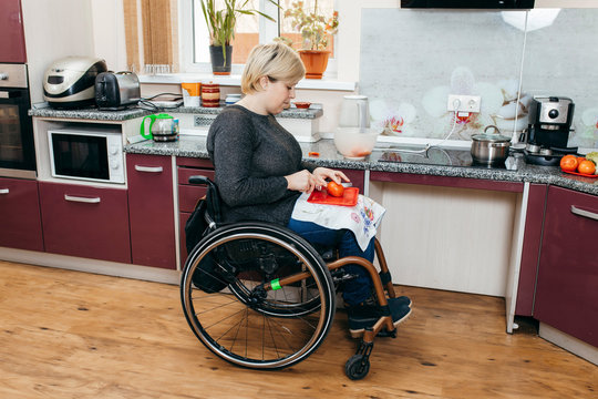 Disabled Woman Making salad In Kitchen