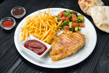 chicken, french fries, sauce on a white plate