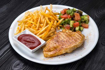 chicken, french fries, sauce on a white plate