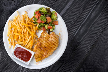 chicken, french fries, sauce on a white plate