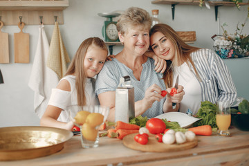 Family in a kitchen. Grandparents with grandchildren. People with vegetables