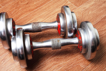two dumbbells are on the gym floor