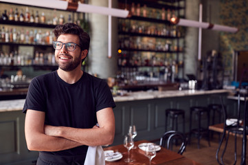 Male Waiter Standing In Bar Restaurant Before Service