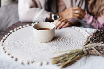 A girl drinks tea in a wrap. Homemade tea drinking. Girl warms up with tea. 