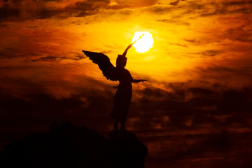 A statue of an angel pointing to the sky